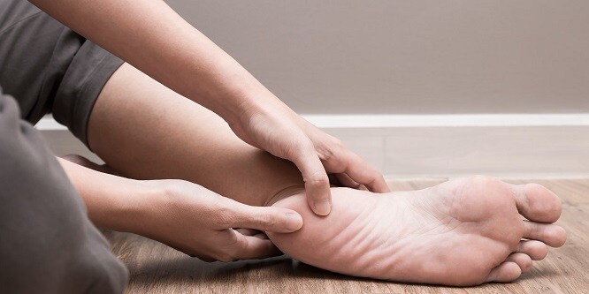 Une personne observant une ampoule au pied
