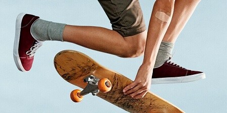 garçon sur un skateboard avec un patch au coude
